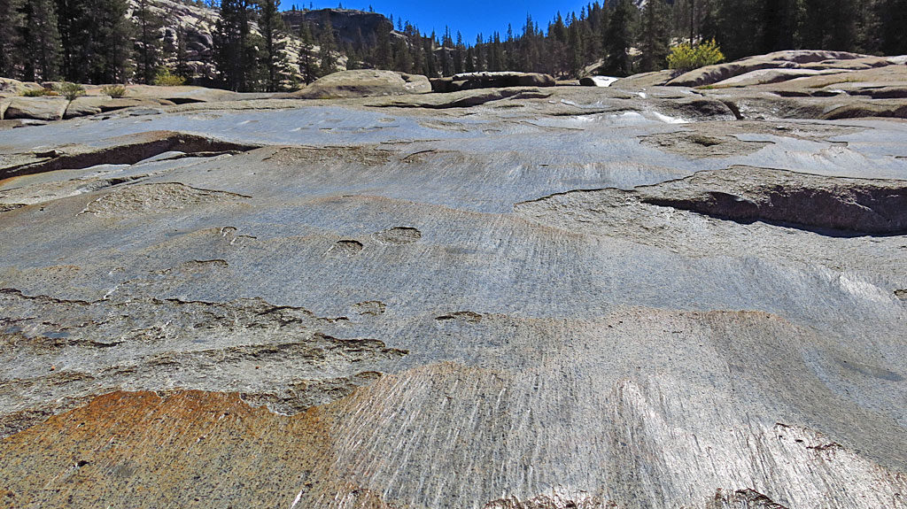 "Glacial polish is a characteristic of rock surfaces where glaciers have passed over bedrock, typically granite or other hard igneous or metamorphic rock. Moving ice will carry pebbles and sand grains removed from upper levels which in turn grind a smooth or grooved surface upon the underlying rock. The presence of such polish indicates that the glaciation was relatively recent ..." -- Wikipedia