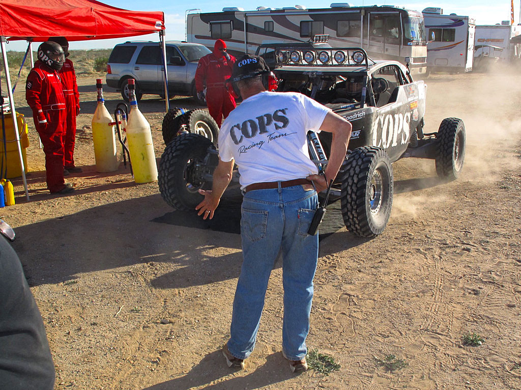 Zak bringing the Class 1 home. He will stop when his front left tire touches Joe's hand, spotting the car for fueling and driver change.