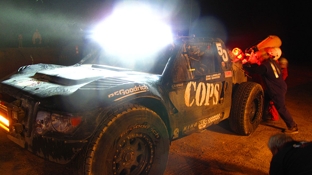 Dan Martin arrives in the COPS Trophy Truck and takes on fuel for his trip over the mountains to the next pits near Loreto. Dan Martin arrives in the COPS Trophy Truck and takes on fuel for his trip over the mountains to the next pits near Loreto.