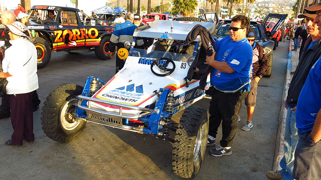 Mark McMillian's Baja-winning #83 1979 Chenowth Class 2 car. When one of the COPS Crew Members walked past, Mark called him over and bragged, \"Hey, you guys don't have one of these.\" He pushed a button on his dash and a digital read-out said \"Beer me! Beer me!\"