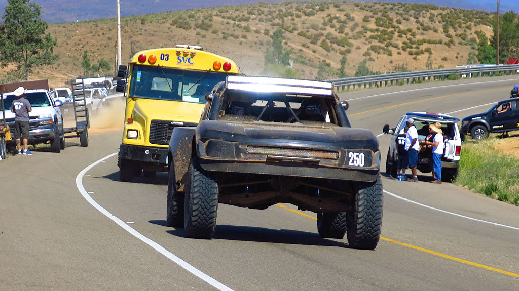 John leaves the dirt and enters Highway 1 outrunning a bus.