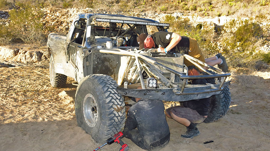 Mike, Mike, and Steve work on repairing the #250. It's always handy when you can lift the fiberglass hood off the truck and put it somewhere out of your way.