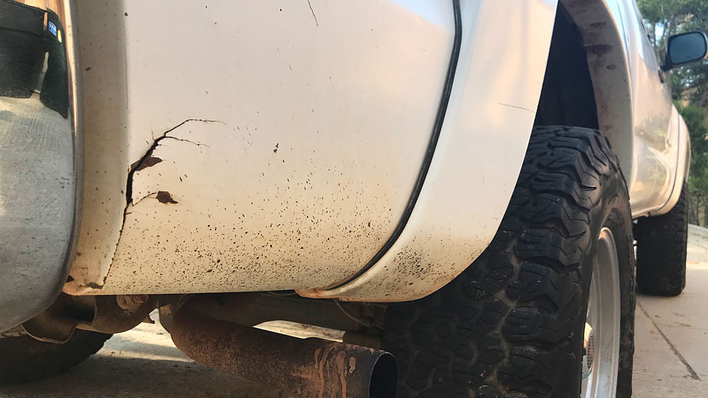 Sheet metal tears in both rear fenders, rear of the wheel