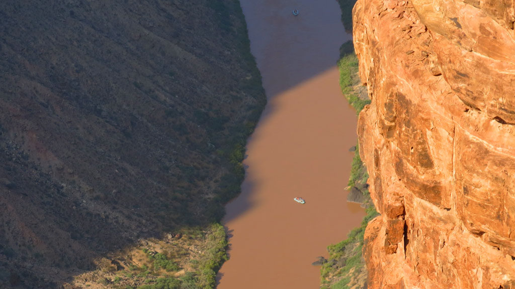 Two river rafters approach Lava Falls in the early morning. The falls is rated a Class 10, meaning it is the highest degree of difficulty in the Grand Canyon, falling 37 feet in a few hundred feet. Rafters only pretend to be in control.